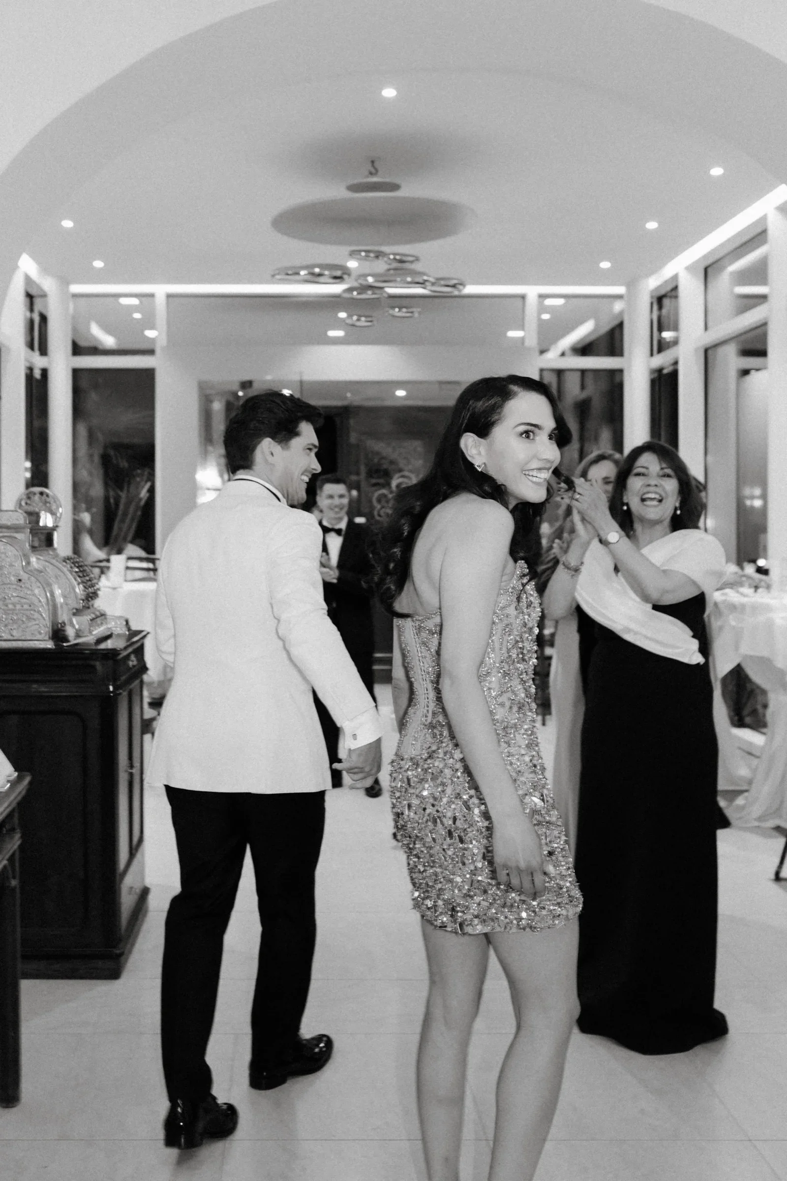 Couple walking through the reception hall past guests