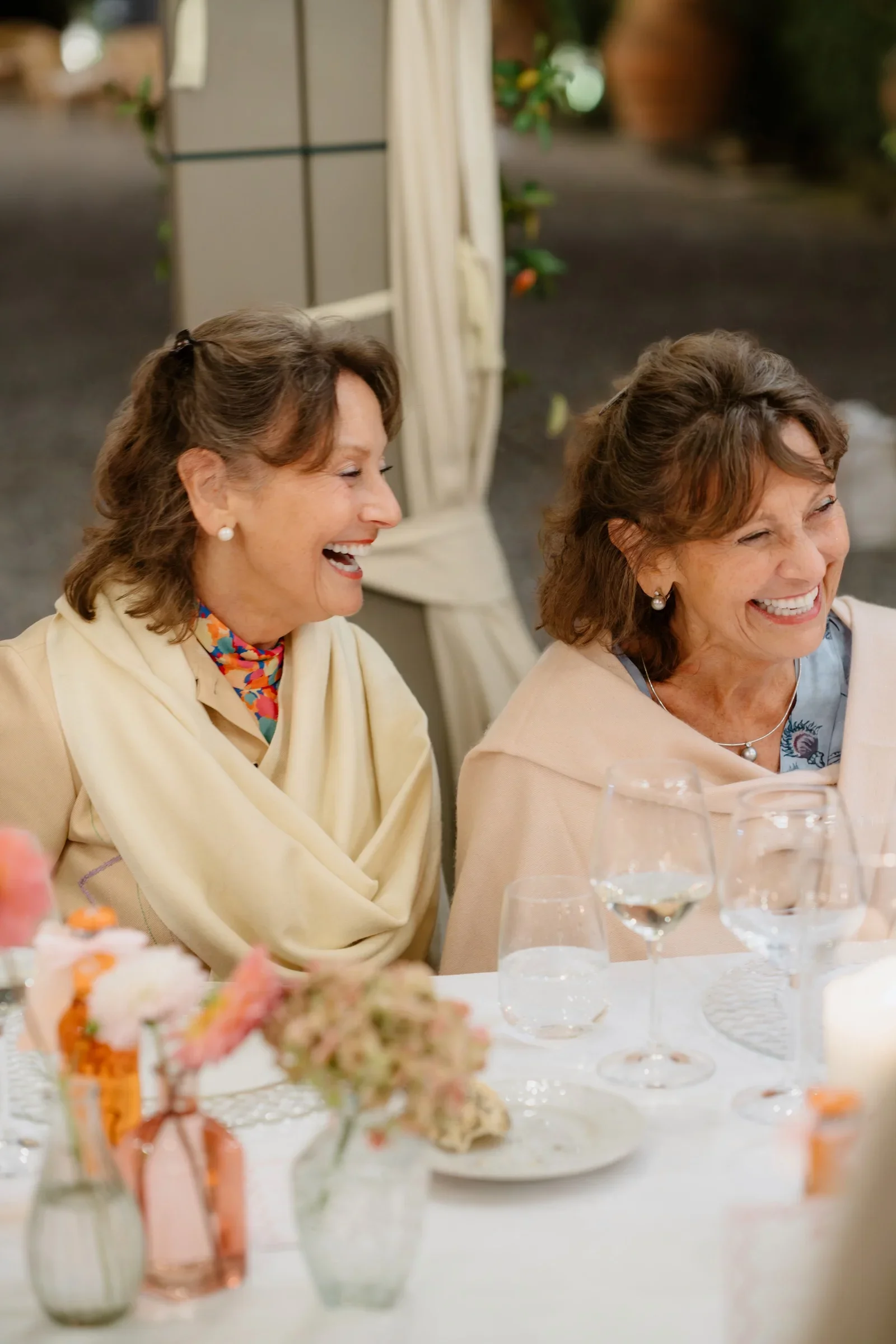 Two guests laughing together at the dinner table