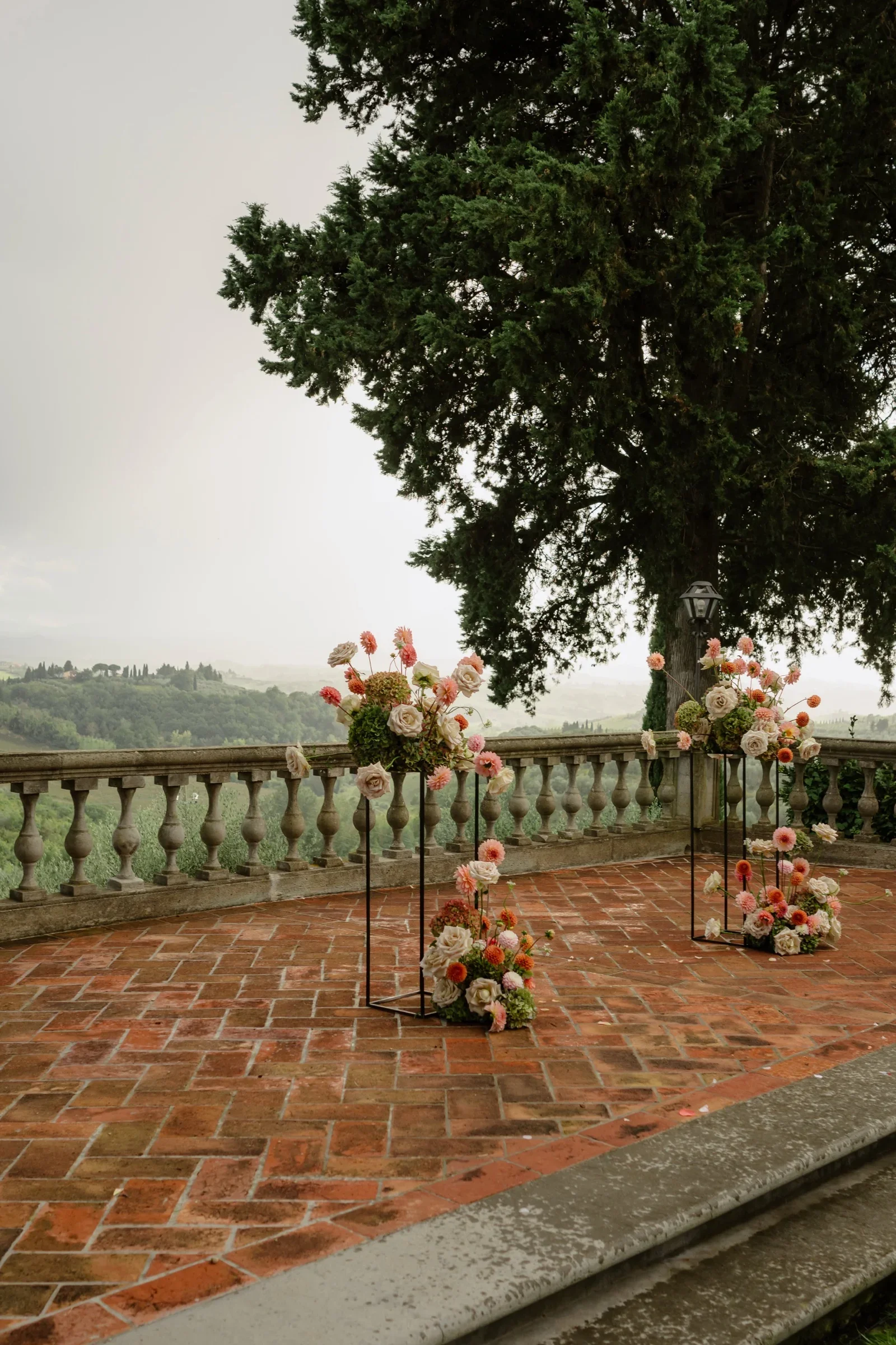 Two urns of peach and cream flowers framing the empty ceremony terrace
