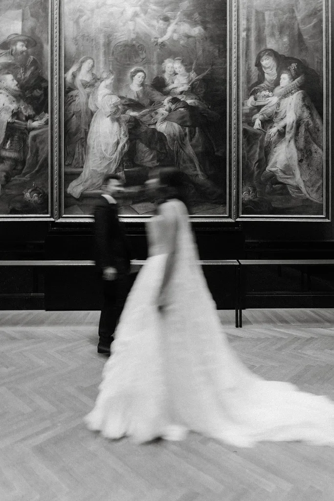 Couple sweeping through a museum gallery past old master paintings