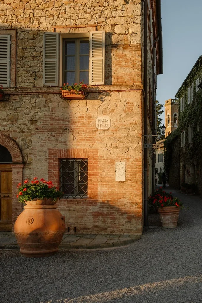 Sunlit corner of an old stone village with terracotta flower pots