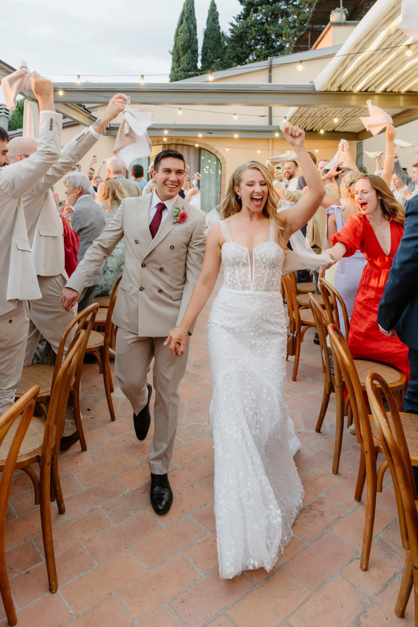 The couple entering the dinner through raised arms and cheering guests
