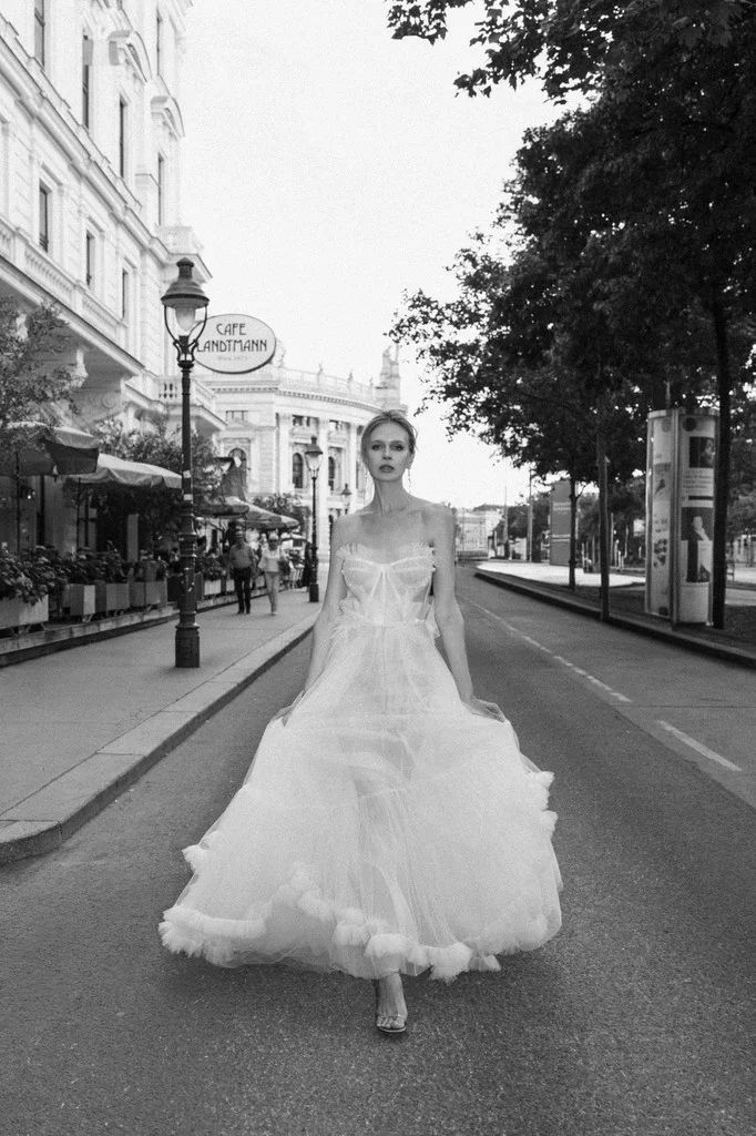 Bride walking down an empty city boulevard in a tulle gown
