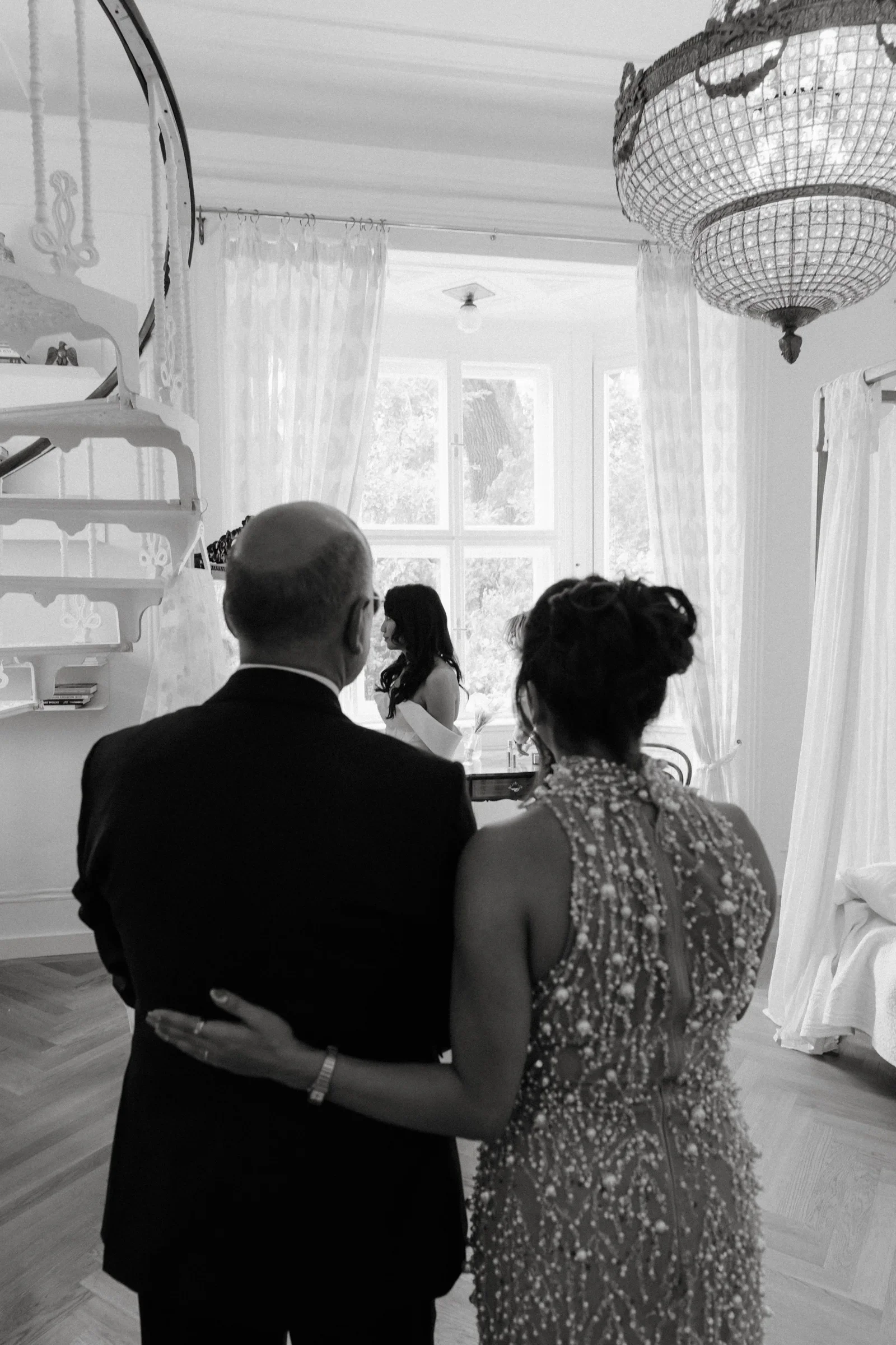 Black and white photo of the groom's father embracing the mother of the bride