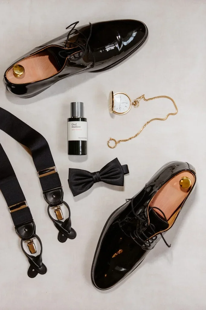 Patent shoes, braces, bow tie and pocket watch laid out for the groom