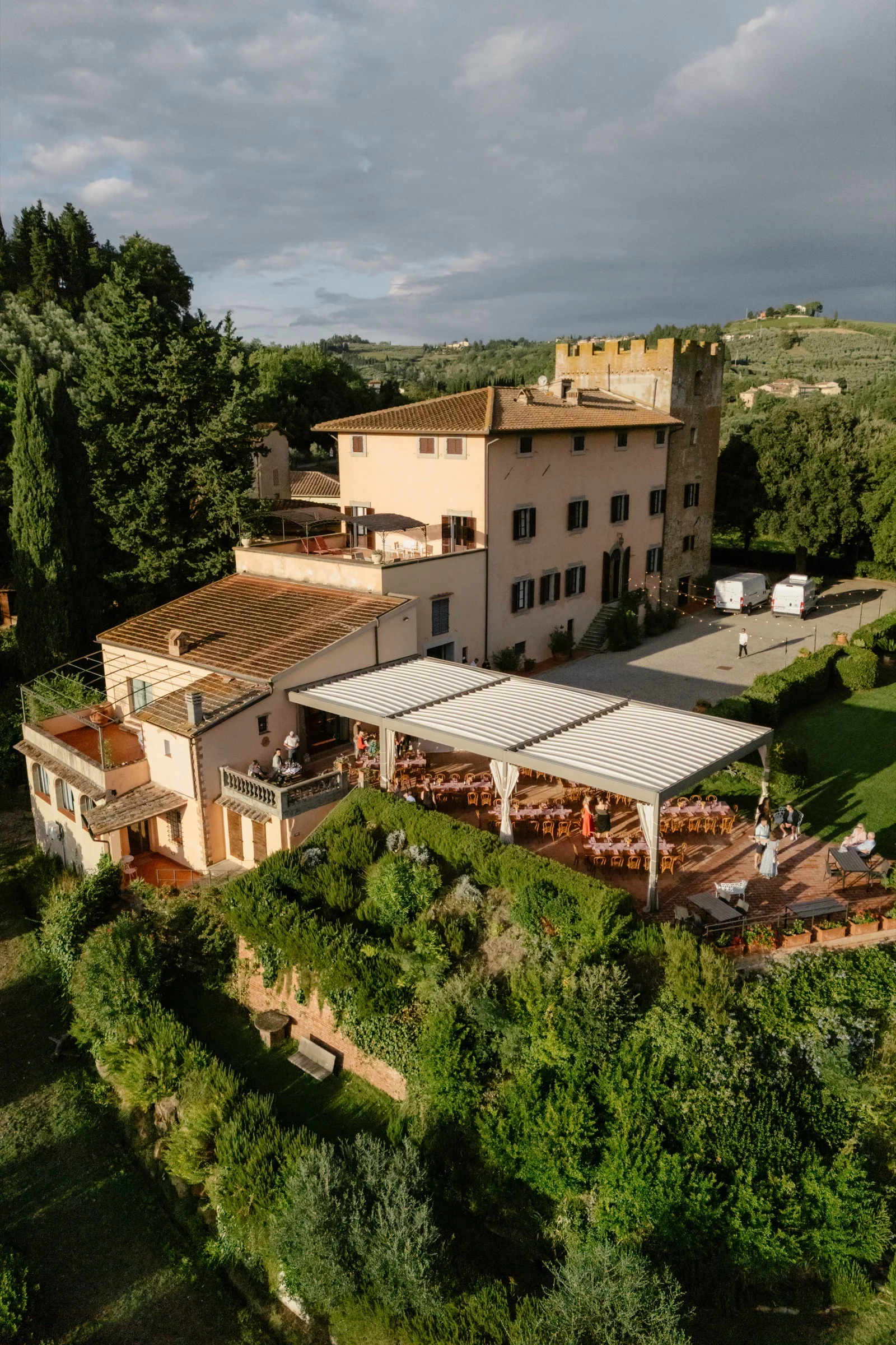 Villa Il Pozzo from the air in evening light, its terrace and pergola set above olive groves
