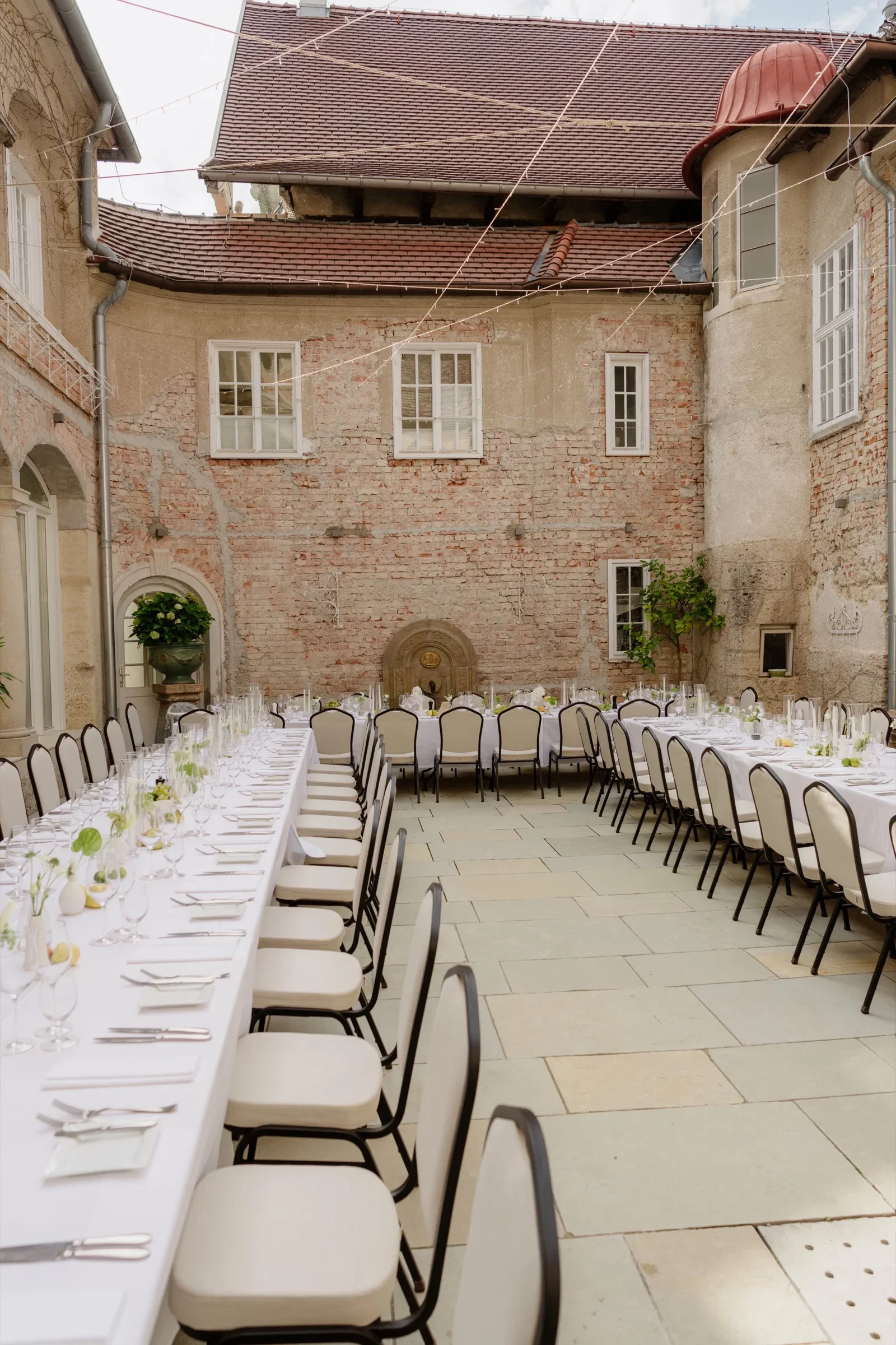 Long banquet table set in a castle courtyard