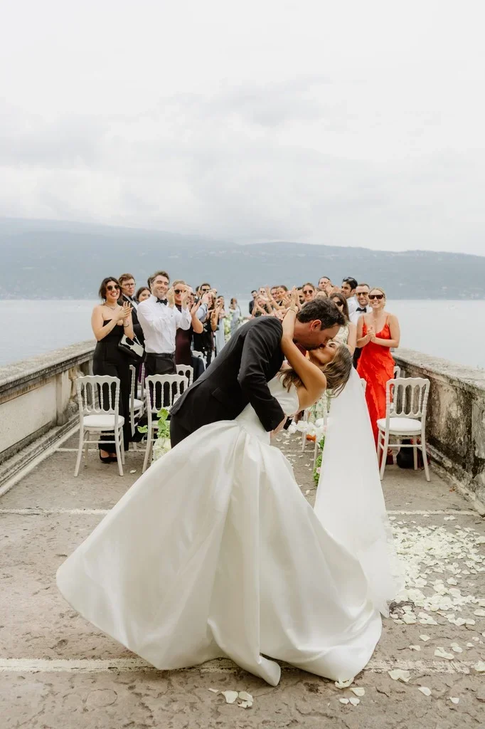 Groom dipping his bride for a kiss at a clifftop ceremony