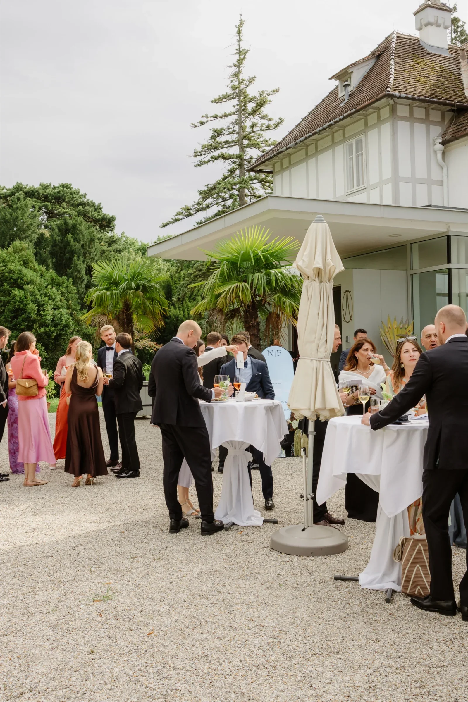 Guests mingling around cocktail tables in the castle courtyard