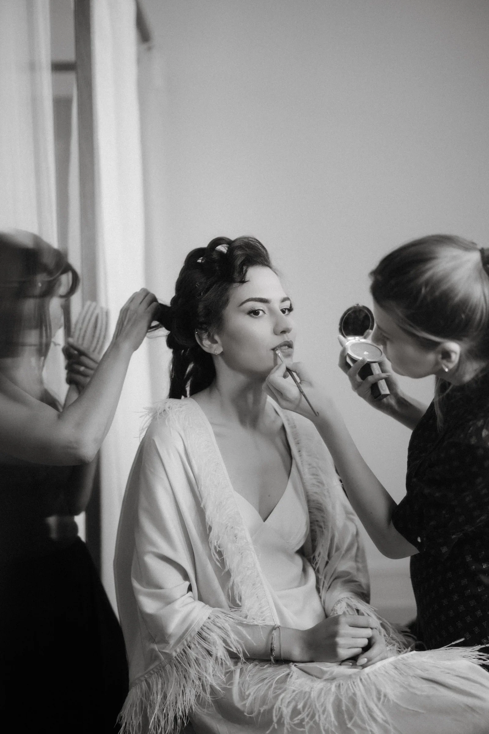 Black and white photo of the bride having her hair and makeup done