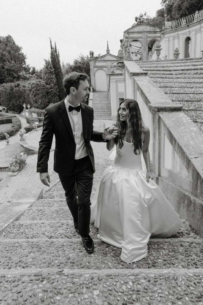 Couple walking hand in hand down a grand garden staircase