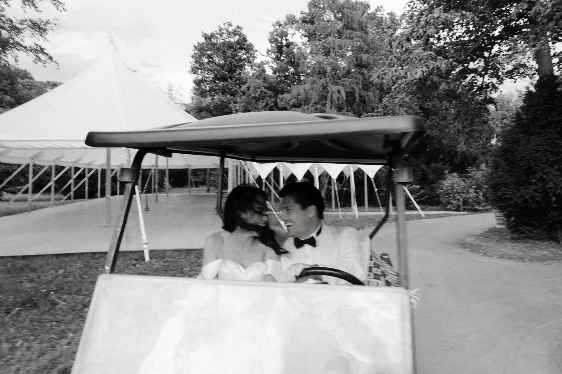 Couple kissing in a golf cart, black and white