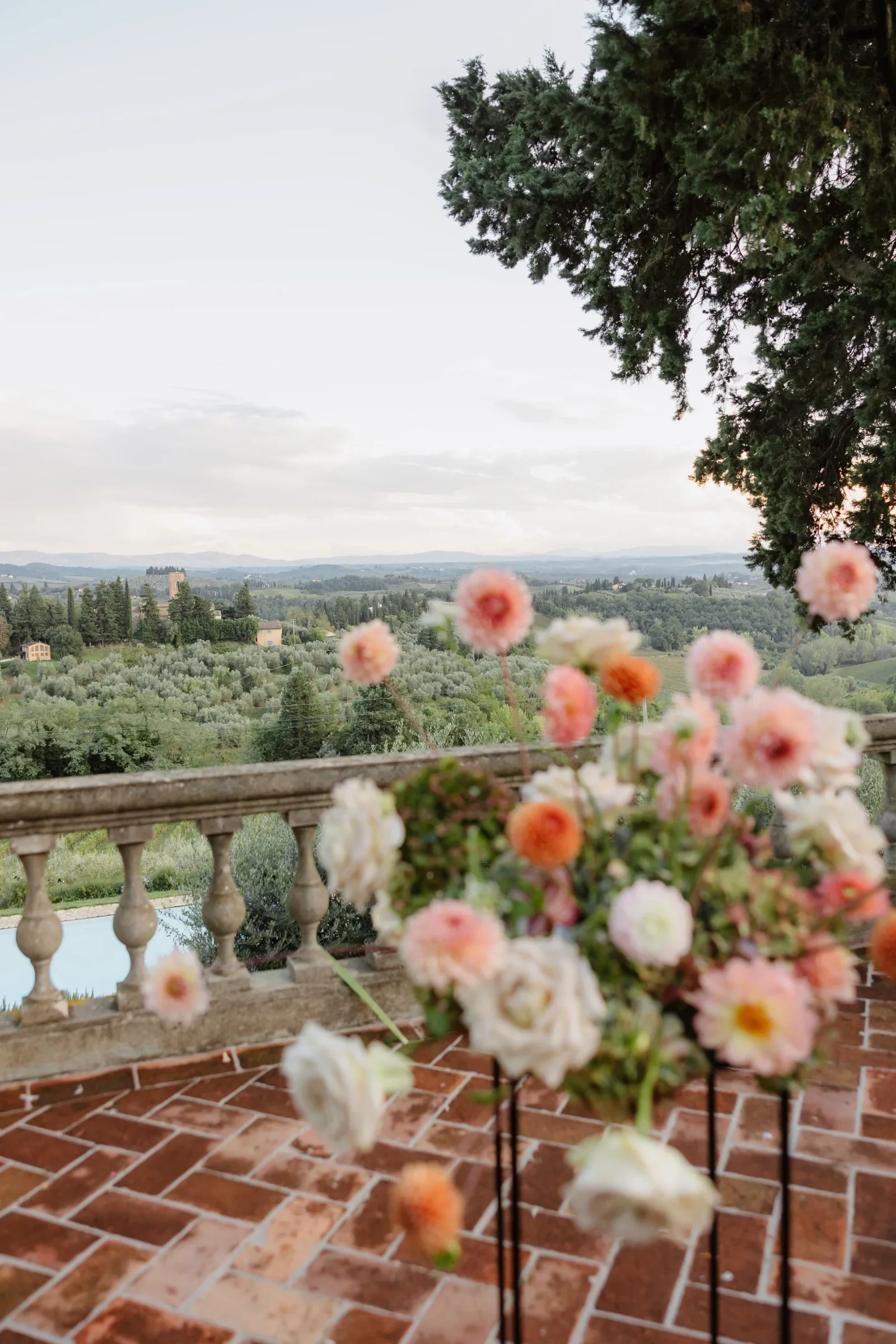 Peach and cream flower arrangement on the terrace balustrade, valley beyond