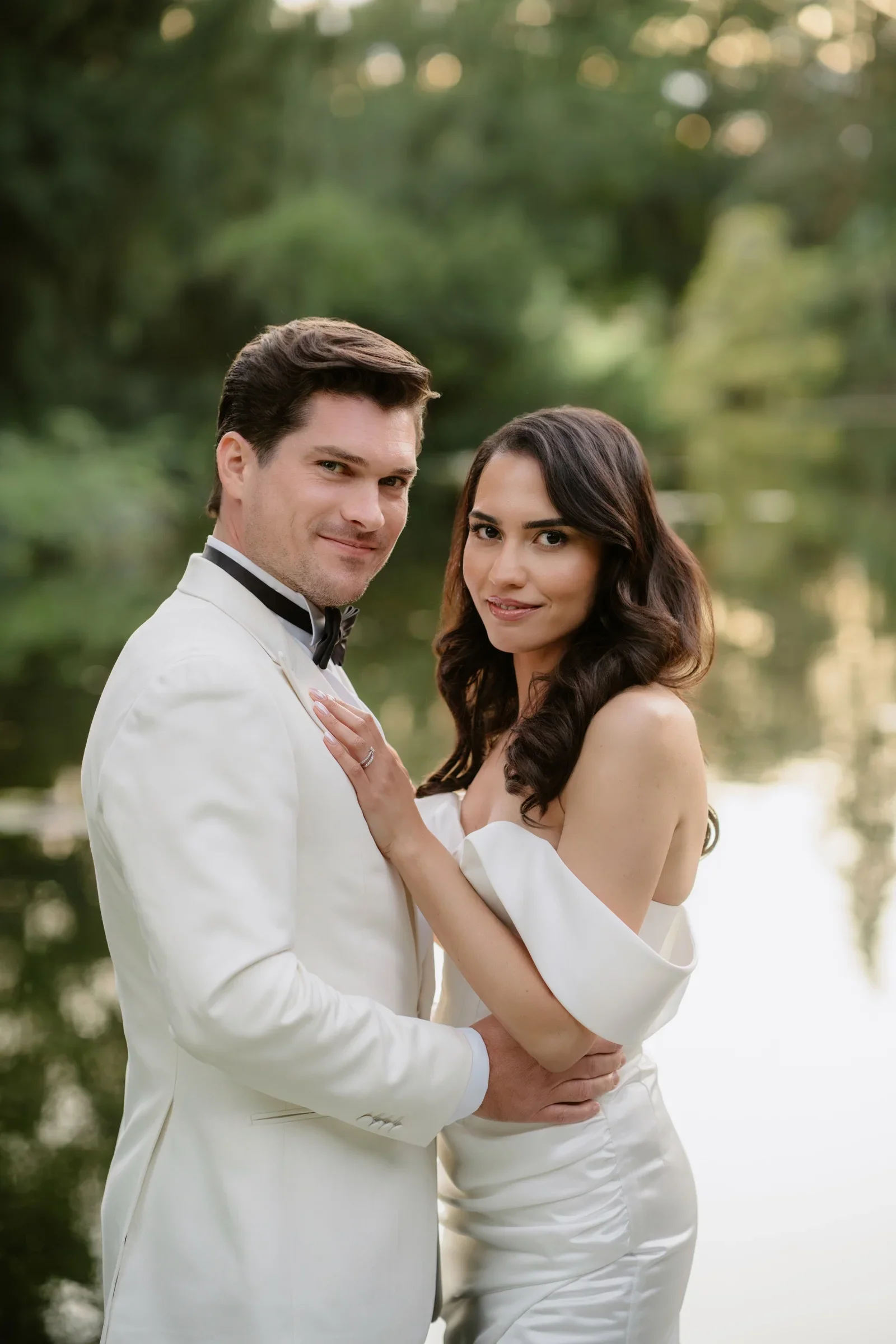 Close portrait of the couple, the groom in a white dinner jacket embracing the bride