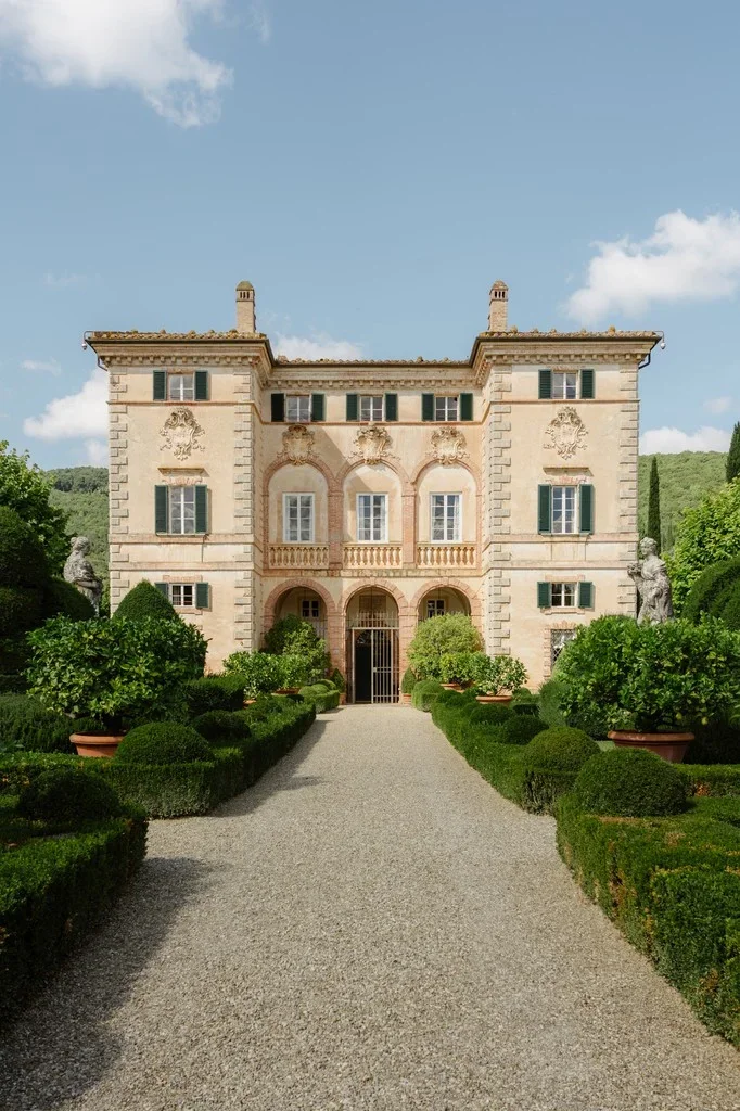 Renaissance villa at the end of a gravel drive lined with topiary