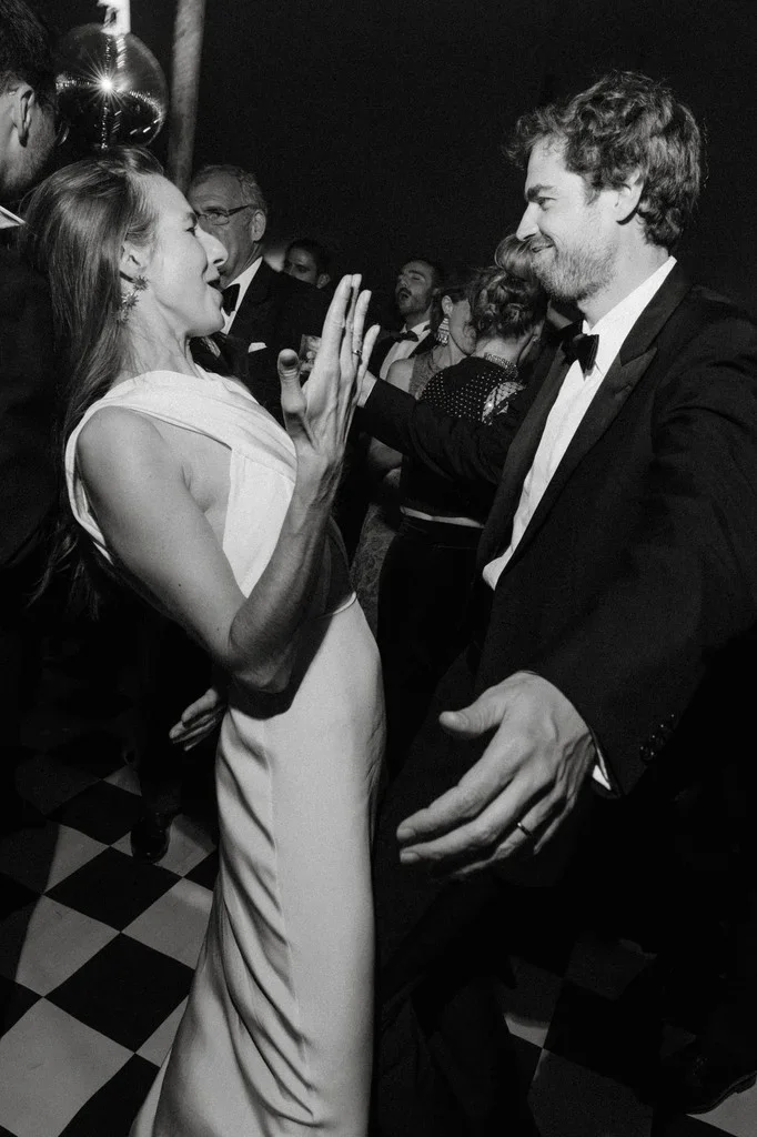Couple dancing and laughing on a black and white checkered floor