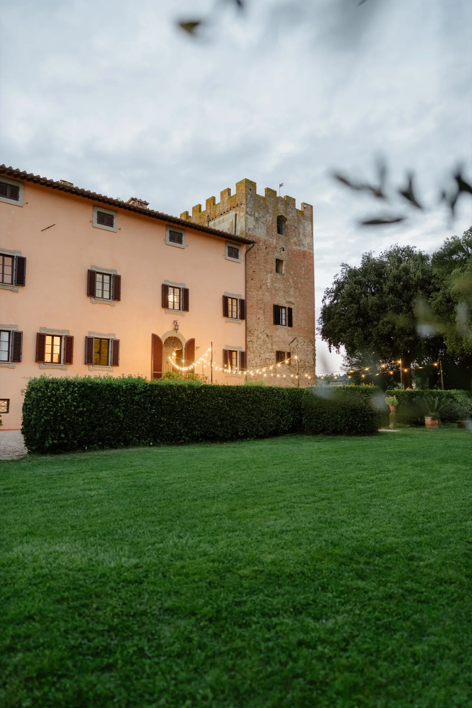 The villa and its tower at dusk, swifts crossing the sky above the lawn
