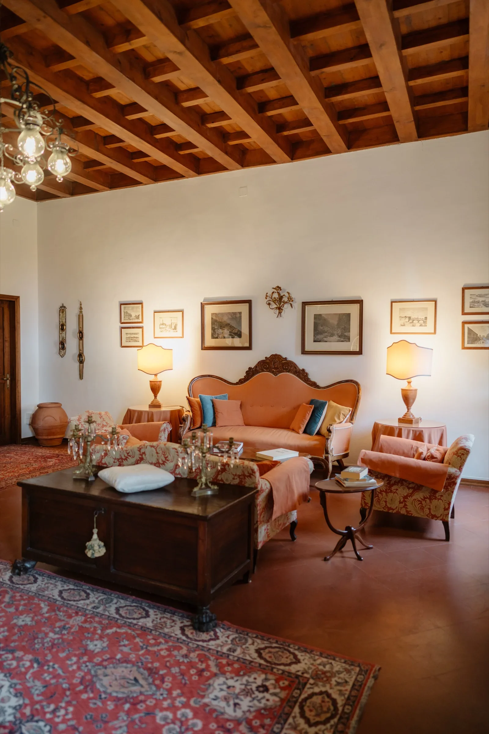 The villa's sitting room with beamed ceiling, antique rugs and a pink velvet sofa