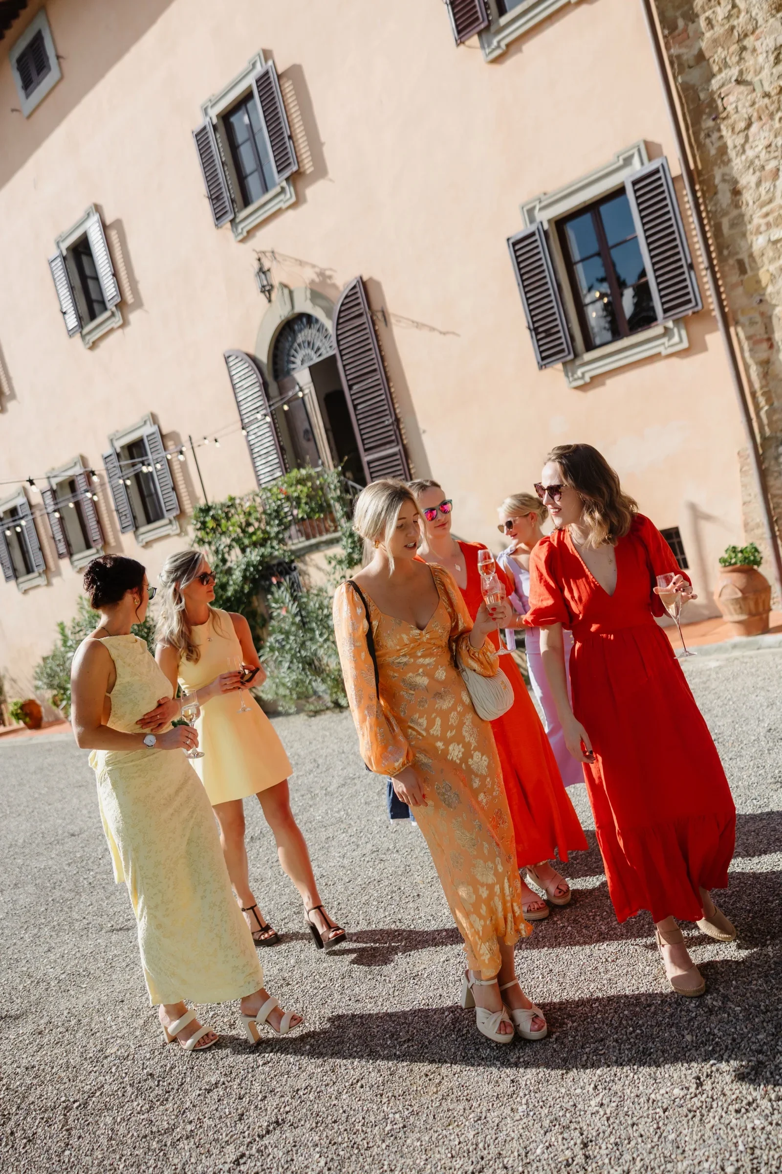 Guests walking along the villa's pink facade towards the ceremony