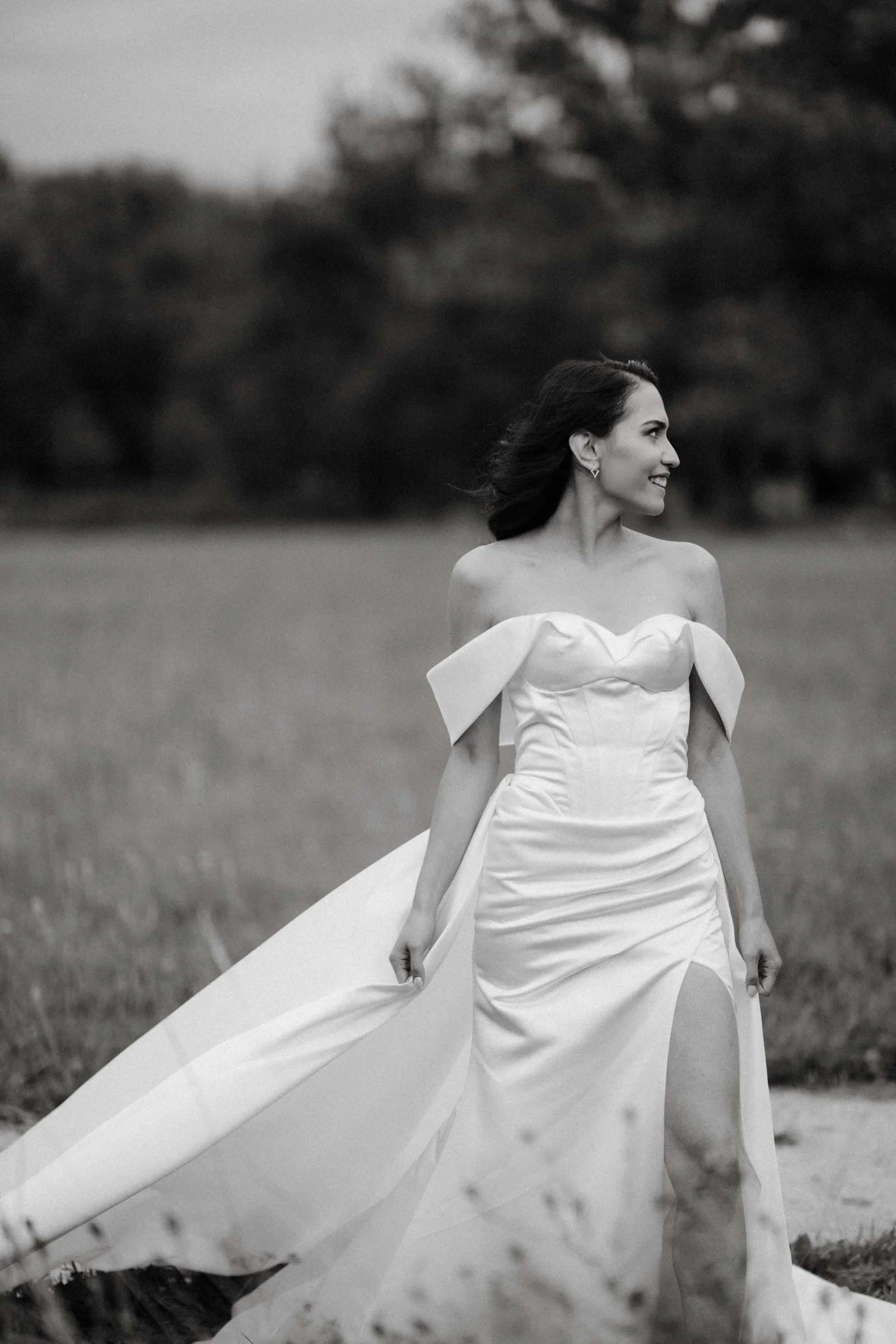 Bride with her train blowing in the wind, black and white