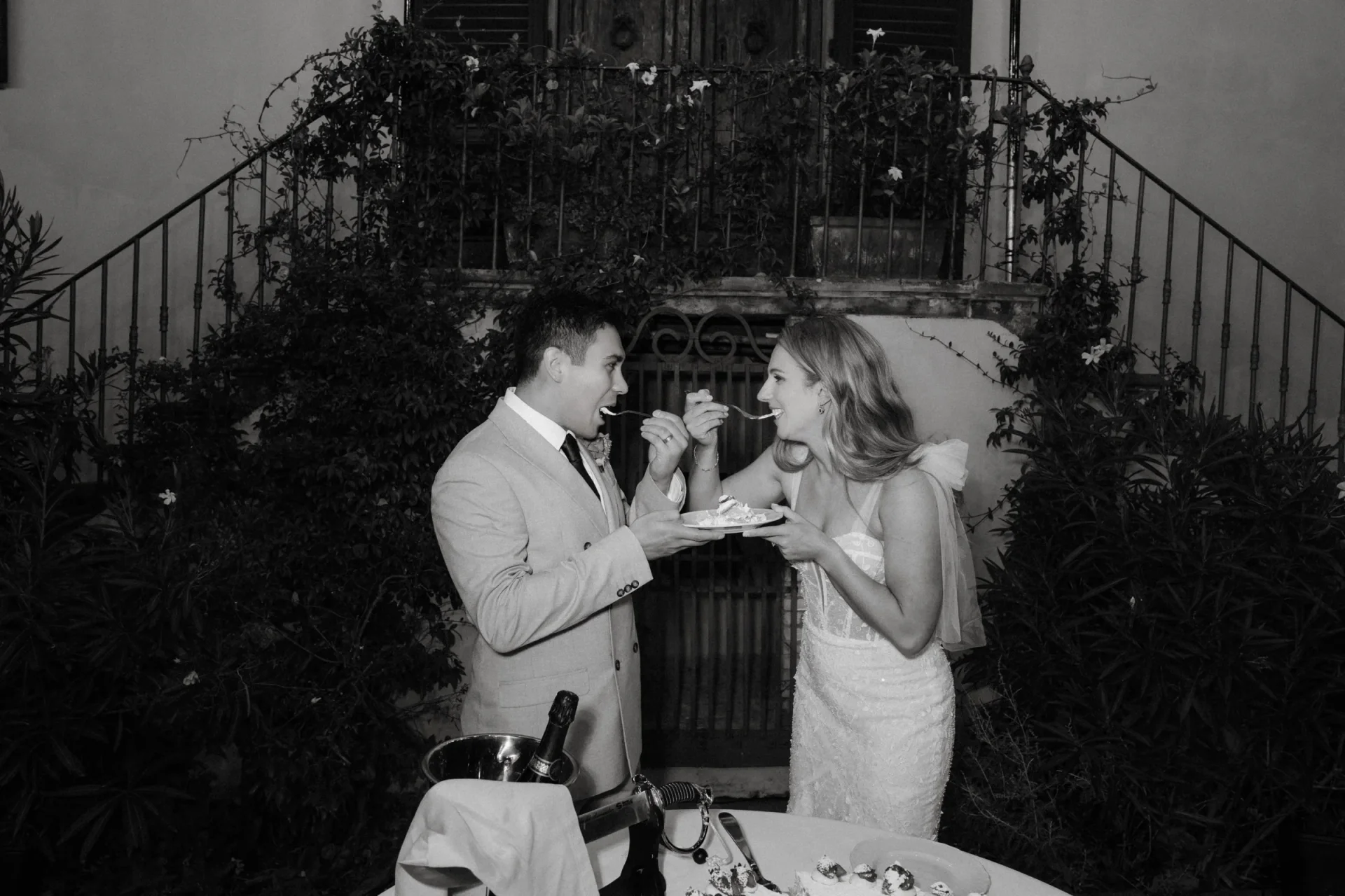 Black and white: the couple feeding each other the first slice of cake