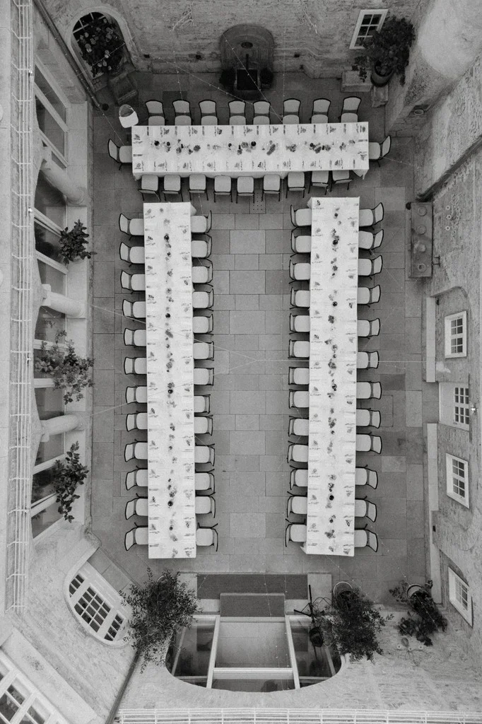 Overhead view of banquet tables laid out in a stone courtyard