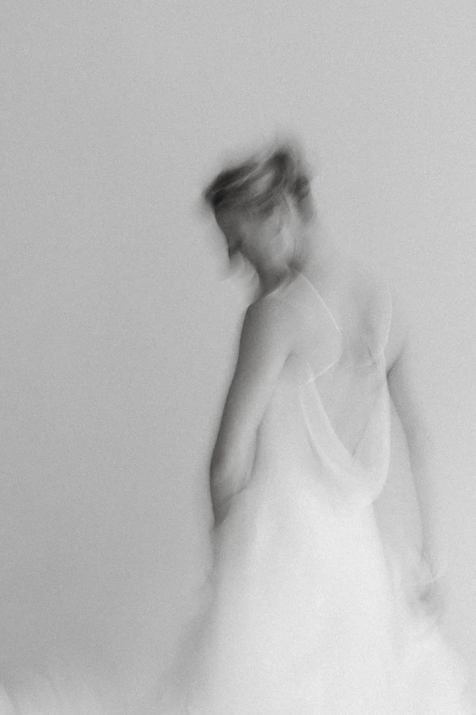 Motion-blurred portrait of a bride turning in a pale gown